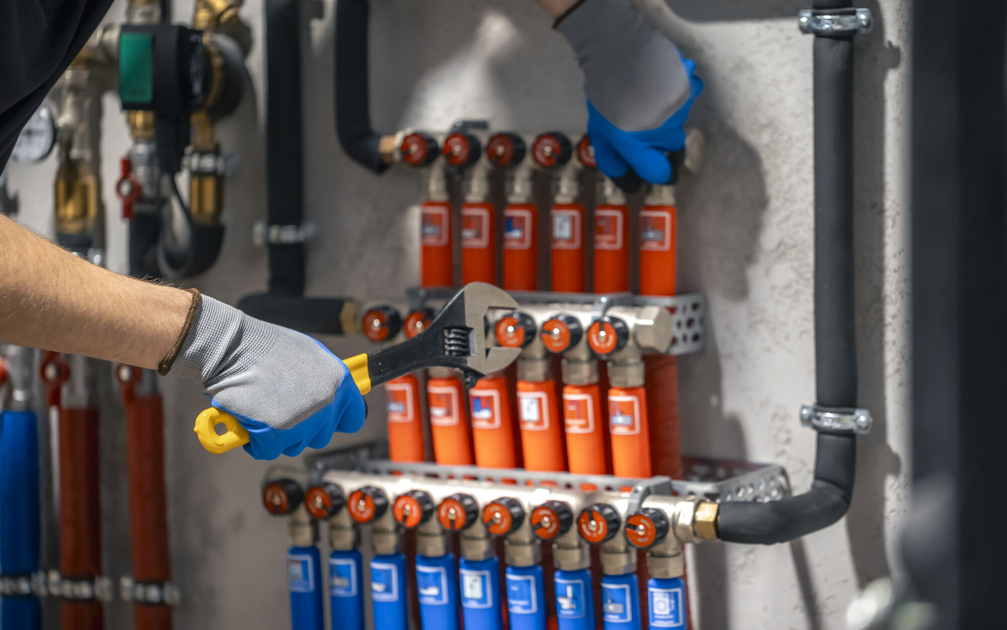 Heating engineer adjusting a central heating manifold (stock photo)